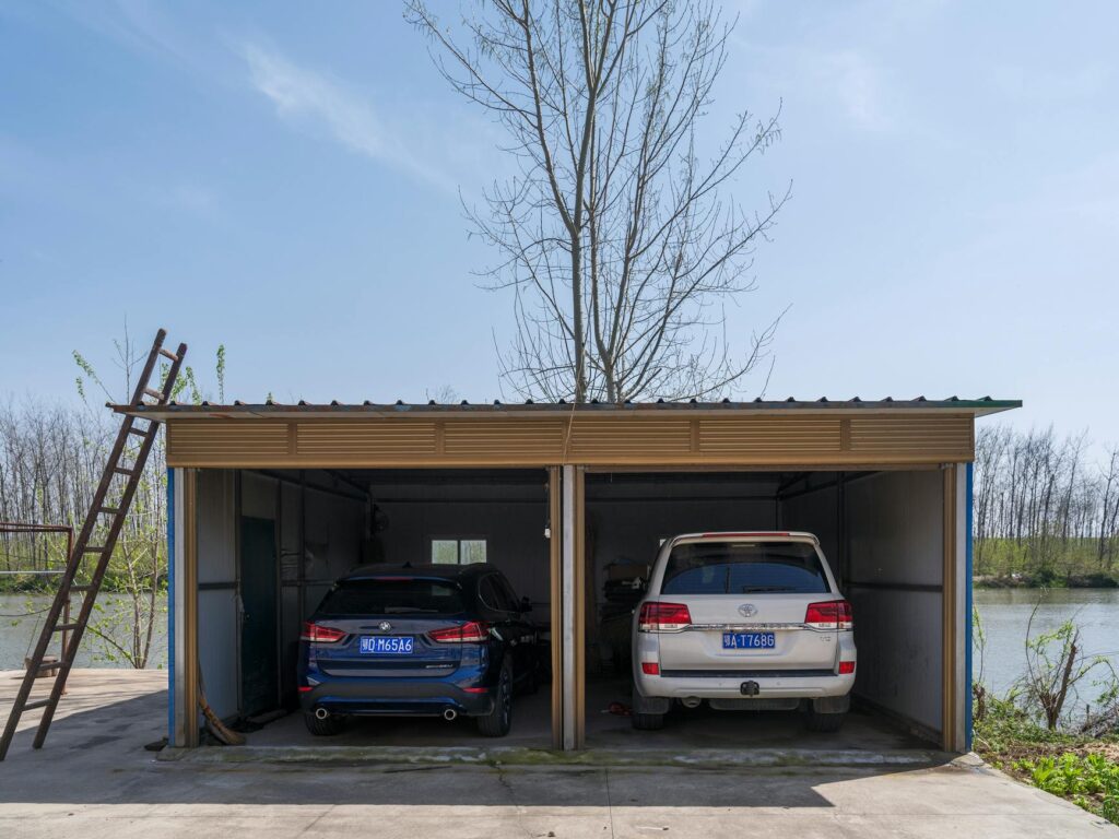 Spacious double garage housing a BMW and Toyota next to a scenic river.