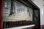 A collection of hand tools neatly arranged on a pegboard for easy access and organization.