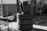 Black and white photo of stacked tires in a garage environment highlighting industrial themes.