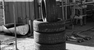 Black and white photo of stacked tires in a garage environment highlighting industrial themes.