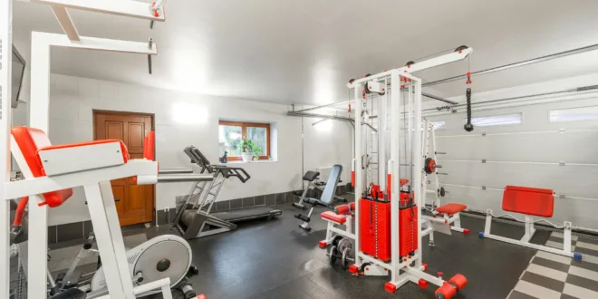Modern interior design of new spacious fitness gym for home sport training and heavy weightlifting in garage of big house