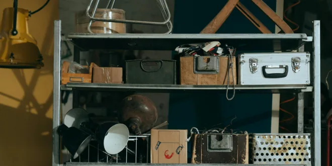 A shelf in a workshop holding vintage and retro objects, showcasing old storage boxes and tools.