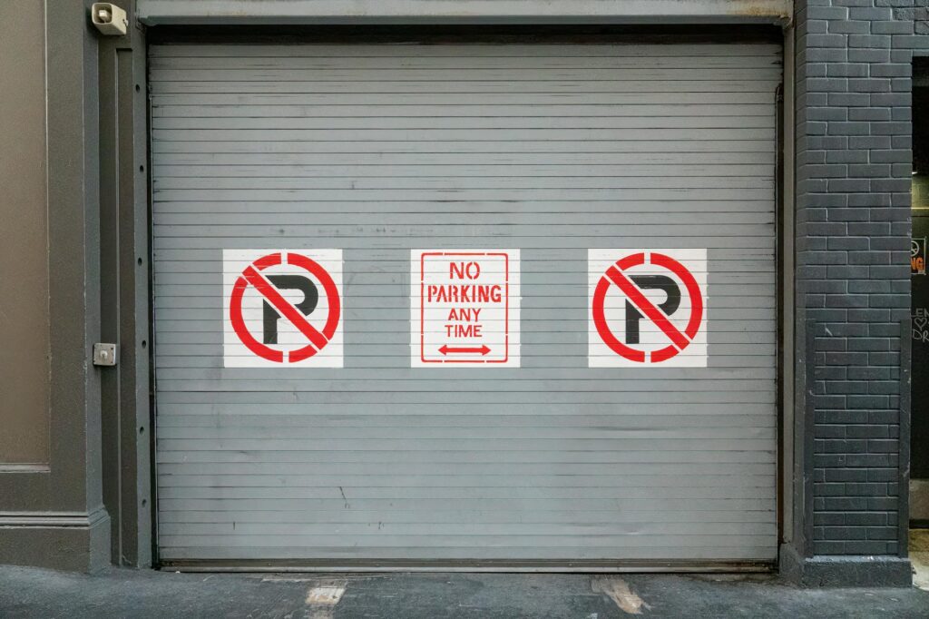 Steel garage door with no parking signs in San Francisco, outdoor urban scene.