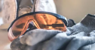 Close-up of safety glasses and gloves with a respirator, highlighting protective equipment.
