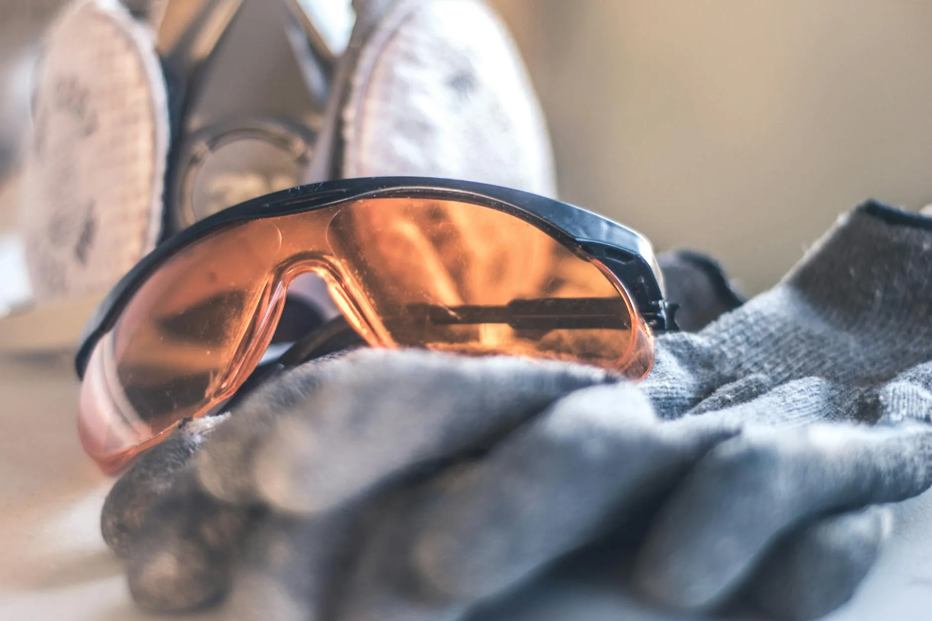Close-up of safety glasses and gloves with a respirator, highlighting protective equipment.