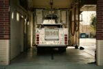 A fire truck parked inside a station's garage, showcasing emergency preparedness.