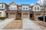 Elegant suburban brick townhouses with driveways in an upscale neighborhood.
