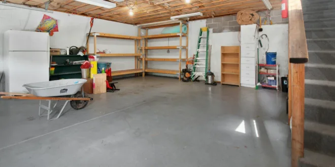 Spacious garage interior with storage shelves, tools, and a wheelbarrow, ideal for home organization.