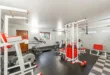 Modern interior design of new spacious fitness gym for home sport training and heavy weightlifting in garage of big house