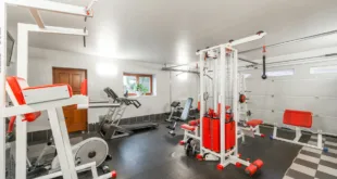 Modern interior design of new spacious fitness gym for home sport training and heavy weightlifting in garage of big house