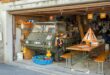 A military vehicle and various items in a crowded garage with Swiss decor.