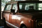 Close-up of a vintage SUV showcasing its retro design in a dimly lit indoor setting.