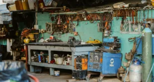 A cluttered workshop with tools, welding equipment, and storage solutions.